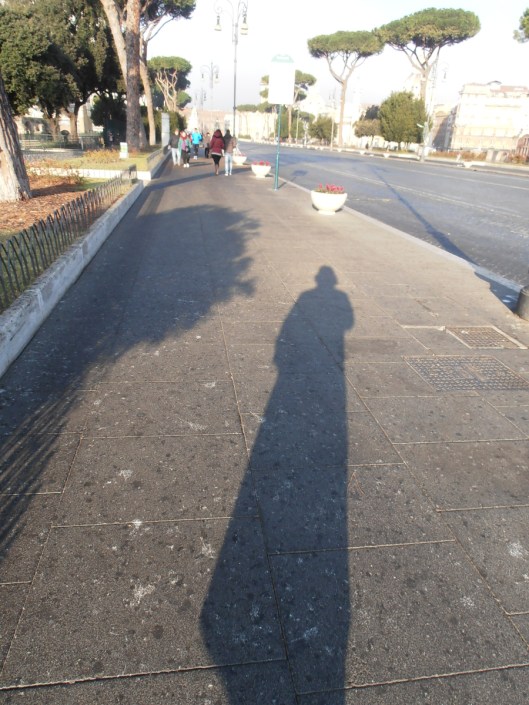 Roma, 20 dicembre 2015. Passeggiata mattutina in via dei Fori Imperiali, con il sole alle spalle.